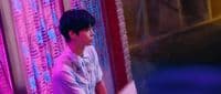 a young man standing in front of a pink curtain