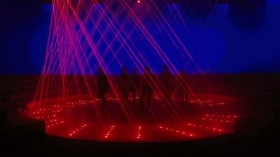 a group of people standing in front of a red and blue light