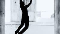 a black and white photo of a person jumping in the air