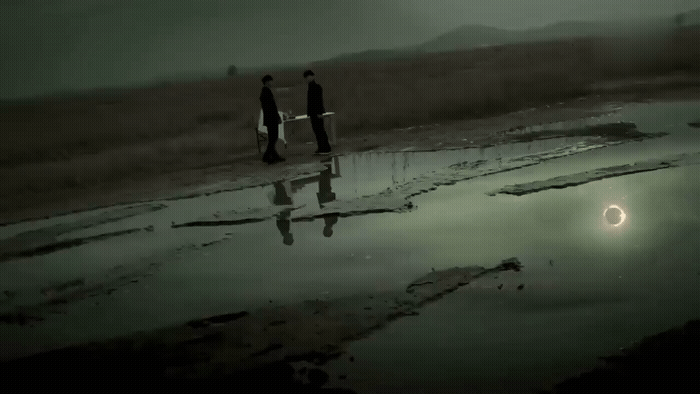 a couple of people standing next to a body of water