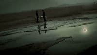a couple of people standing next to a body of water