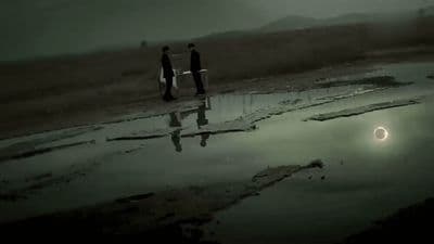 a couple of people standing next to a body of water