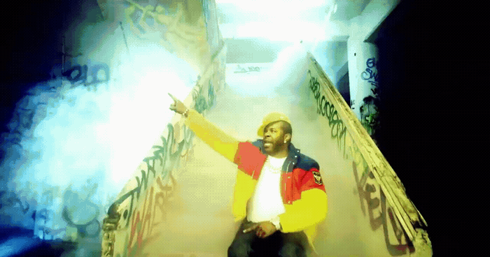 a man in a yellow and red jacket standing on a staircase