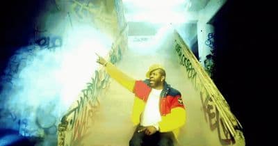 a man in a yellow and red jacket standing on a staircase