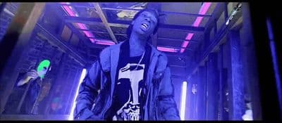 a man standing in a room with purple lights