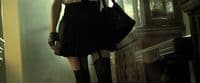 a woman in a short black dress holding a purse
