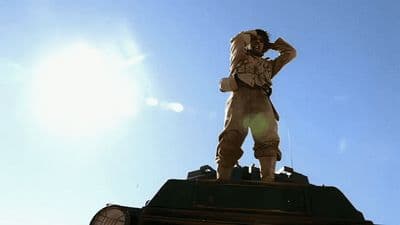 a statue of a man standing on top of a clock tower