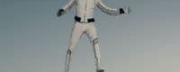 a man in a white suit standing on a snowboard
