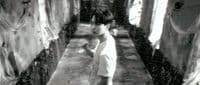 a young boy is walking through a dirty room