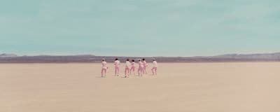 a group of people standing in the middle of a desert