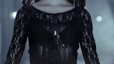 a woman in a black dress with a bird on her shoulder