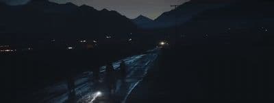 a car driving down a road at night