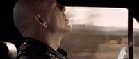 a bald man sitting in a car looking out the window