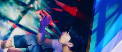 a man sitting in front of a colorful wall
