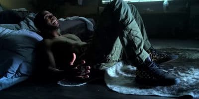 a man laying on a bed in a dark room
