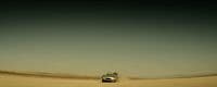 a car driving through the desert on a clear day