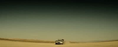 a car driving through the desert on a clear day