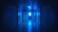 a long hallway with blue light coming from the ceiling