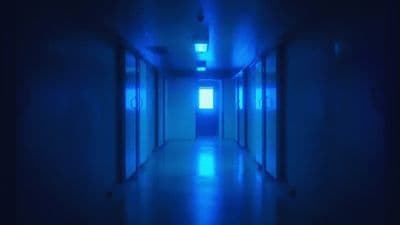 a long hallway with blue light coming from the ceiling