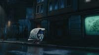 a person in a white jacket is standing in the rain