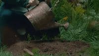 a woman in a green dress holding a watering can
