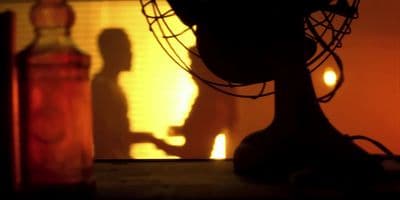 a shadow of a person standing next to a bottle