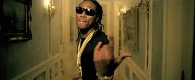 a man wearing sunglasses and a jacket making a peace sign