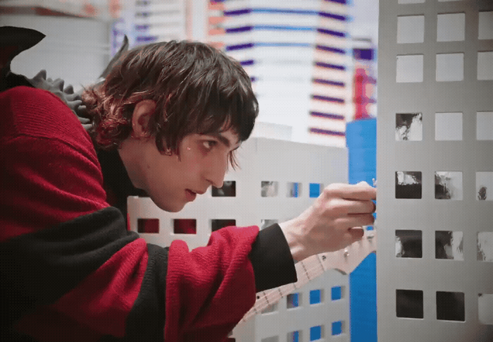 a man in a red sweater is looking at a piece of paper