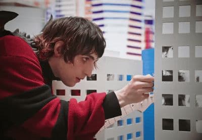a man in a red sweater is looking at a piece of paper