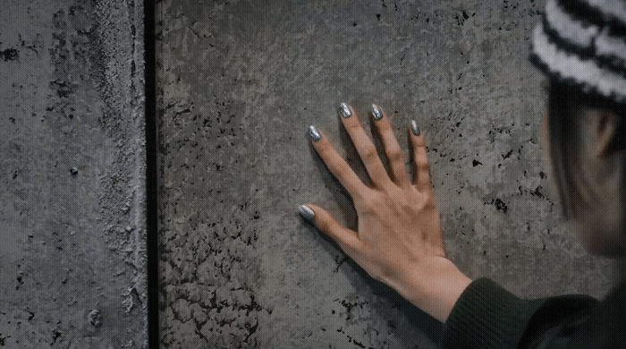 a woman with her hands on a wall