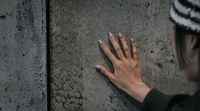 a woman with her hands on a wall