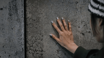 a woman with her hands on a wall