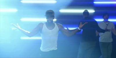 a man in a white tank top dancing on stage
