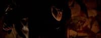 a woman standing in a dark room with her hand on her head