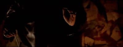 a woman standing in a dark room with her hand on her head