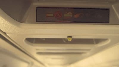 a sign on the ceiling of an airplane