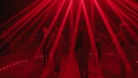 a group of people standing in front of a red light