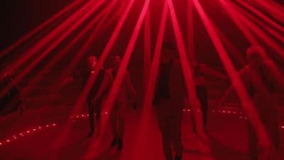 a group of people standing in front of a red light