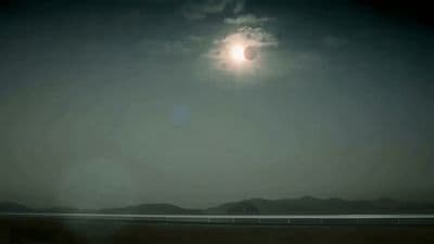 a full moon is seen over a body of water
