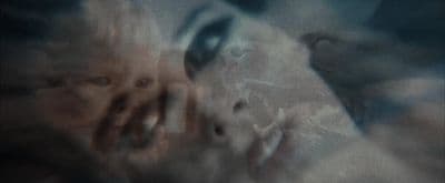 a blurry photo of a woman's face and hands