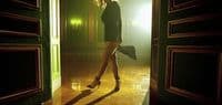 a woman standing in a doorway with her legs crossed