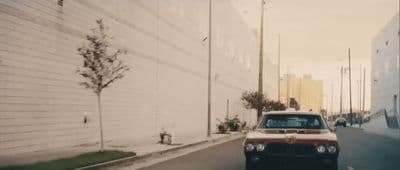 a red and white car driving down a street