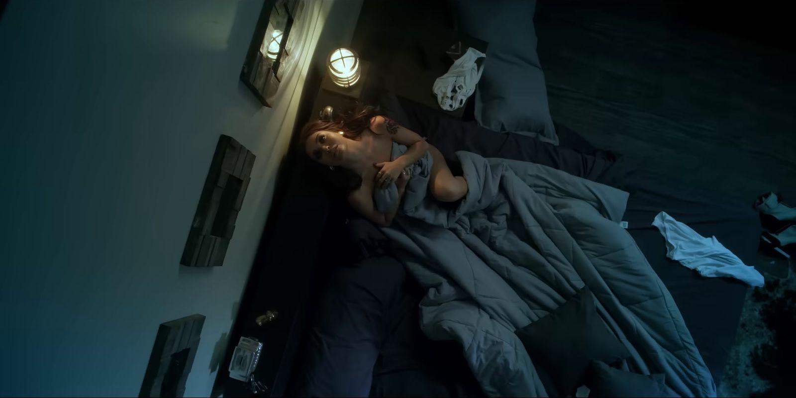 a person laying in a bed in a dark room