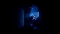 a person sitting in a chair in a dark room