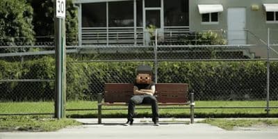 a person sitting on a bench in front of a building