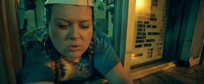 a woman wearing a white hat looking at her cell phone