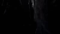 a man standing in the dark with his hands in his pockets