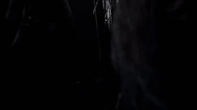a man standing in the dark with his hands in his pockets