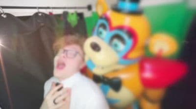 a man standing in front of a stuffed animal