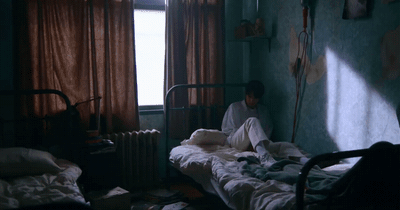 a person sitting on a bed in a room